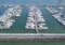 Marine port for yacht, motorboat, sailboat parking service and moorings for luxury and wealthy millionaire in aerial view with man