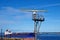 Marine radar tower, rotating antenna. In the background the ship. Marine radar in the port of Venstpisls, Latvia