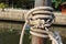 Marine ropes for towing ship bound around pipe steel post in the canal closeup.