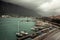 Marine sea port with moored luxury yachts and boats in medieval Kotor bay in Montenegro in overcast rainy autumn day