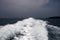 Marine travel ship tail photo. Stormy day seaside landscape. White foam on seawater surface. Motor boat trail