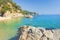 Marine tropical lagoon. Turquoise water on beach with white sand and rocks along coastline. Beaches of Lloret de Mar