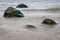 Marine waters surrounded by lone large stones.