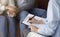 Marital Therapist Taking Notes Talking With Couple In Office, Cropped