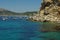 Maritime landscape with rocks entering the sea, with boats on deep blue water and beautiful blue sky, Costa Brava, Spain