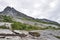 Marked hiking trail to Tvillingene peak going up among grey granite cliffs