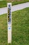 Marker for natural gas pipeline - cathodic test station stuck into green grass by sidewalk