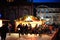 Market stall chalet with multiple toys for sale in Place de la Cathedrale Notre-Dame with tourists locals admiring the