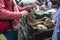 Market stall vendor at an outdoor festival with army surplus ex military items for sale.  Man looking at bags