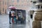 Market trader tries to protect his goods from the downpour