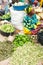 Market woman in Uganda midst garden-freshly harvested green vegetables. Various beans, peppers, avocado, green tomatoes