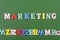 MARKETING word on green background composed from colorful abc alphabet block wooden letters, copy space for ad text