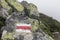 Marking the tourist route painted on stones in red and white. Travel route sign in the Carpathians mountains