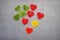 Marmalade hearts in sugar on a chalkboard background. Marmalade multi-colored sweets. Valentine`s Day. Dessert. Red, green and