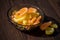 Marmalade lemon slices in a glass vase on a wooden table in the sunlight, close-up, selective focus