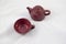 Maroon ceramic teapot on white background