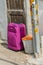 Maroon colored suitcase on street