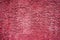 The maroon dilapidated cement wall texture. Dark pink stucco background. Abstract pattern of grunge red concrete wall