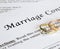 Marriage contract with two golden wedding rings and gold pen, prenuptial agreement, macro close up, sign with signanture