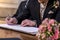 Marriage elegant groom signing german wedding register holding pen and official document couple