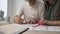 A married couple is actively discussing repairs in a new apartment or house while sitting at a table and making notes in