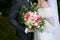 A married couple, the bride and groom hold hands and hold a wedding bouquet. Anxiety before the wedding. Close-up