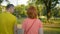 Married couple in colorful summer clothes walks in park in late evening sunset