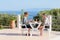 Married couple eating at table on terrace near sea