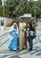 A married couple - husband and pregnant wife in the clothes of Jesus` time - stand with the attendant in front of the Basilica of