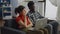 Married couple of interracial partners looking at laptop