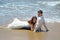 A married couple is lying on the sand on the beach of the Indian Ocean. Wedding and honeymoon in the tropics on the island