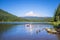 Married couple man and woman kayak along the picturesque Trillium Lake overlooking Mount Hood