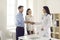 Married couple shakes hands with a female gynecologist while getting acquainted.