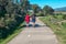 A married couple in sportswear walks quietly with their dog along a livestock path