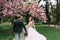 Married couple walking along the avenue of flowering trees