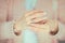 Married woman hands touching her wedding ring closeup, light pink pastel colors