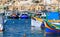 Marsaxlokk fishermen village in Malta. Traditional colorful boats at the port of Marsaxlokk