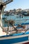 Marsaxlokk, Malta, August 2019. The steering gear of the fishing boat and the city is visible.