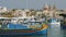MARSAXLOKK, MALTA - July 6, 2016: Beautiful fishing village architecture with colored boats at anchor in a bay