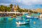 Marsaxlokk, Malta - Traditional colorful maltese Luzzu fisherboat at the old village of Marsaxlokk with turquoise sea water