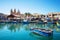 Marsaxlokk market with traditional colorful fishing boats, Malta