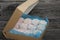 Marshmallow blue and pink. Lies in craft packaging. Decorated with mastic snowflakes. On black pine boards