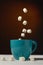 Marshmallow falls into a mug of hot cocoa chocolate drink on a dark background: the concept of winter food and drink, and flying