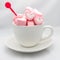Marshmallow hearts in cup on white