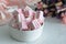 Marshmallow on a light table next to a bouquet of wild field dried flowers. Sweets for tea and coffee on a porcelain plate