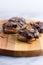 Marshmallow sandwich cookies with cholate topping on wooden board