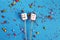 Marshmallows on wooden skewers with color sweets on blue background. holiday concept. sweets in the form of people