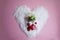 Martenitsa, Martisor with flowers in the snow on a pink background flat lay copy space