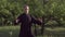 A martial artist practices tai chi taijiquan qigong in nature in a park