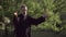 A martial artist practices tai chi taijiquan qigong in nature in a park